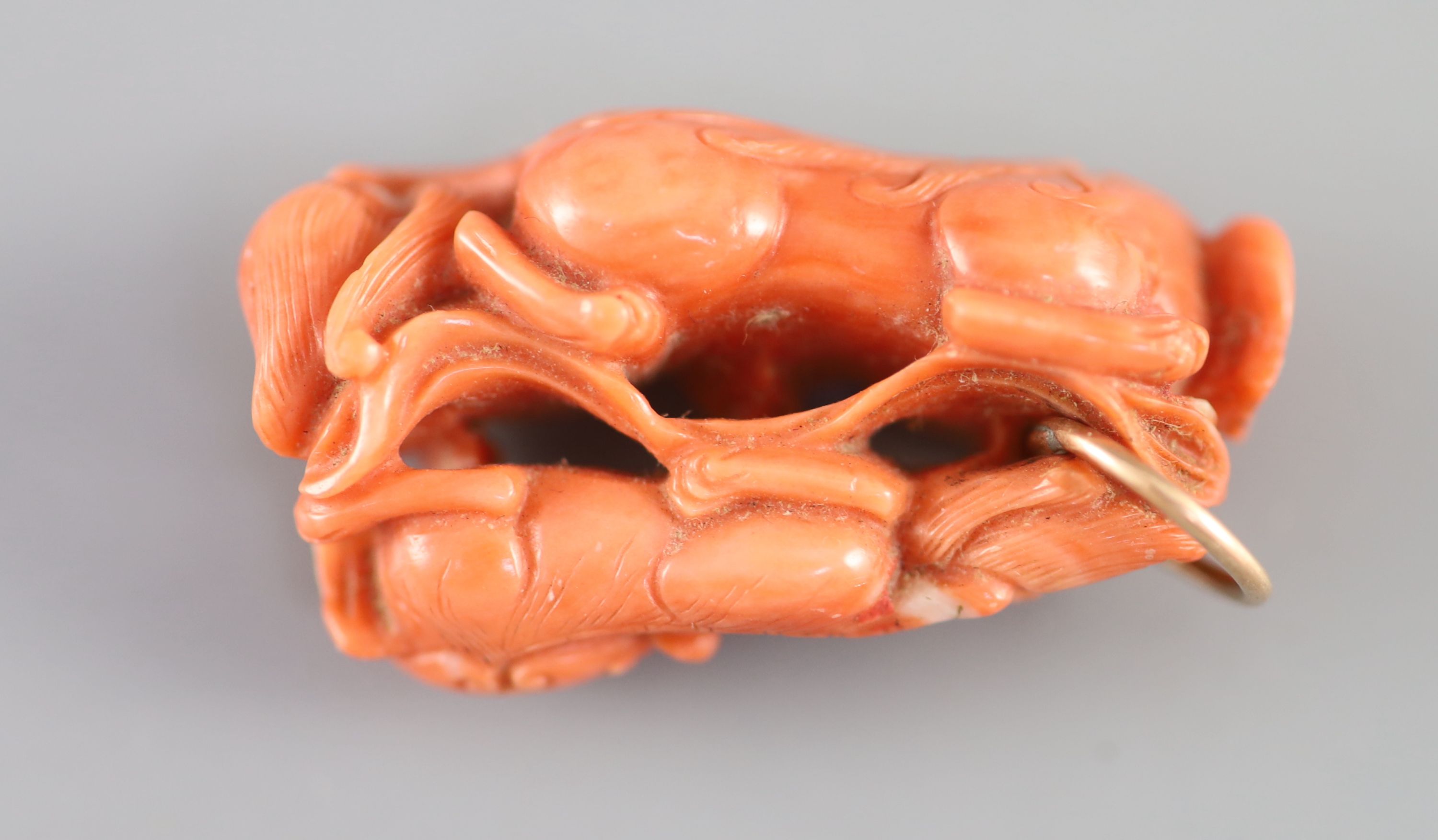 A Chinese coral ‘lion-dog’ pendant, 19 century, 3.8cm